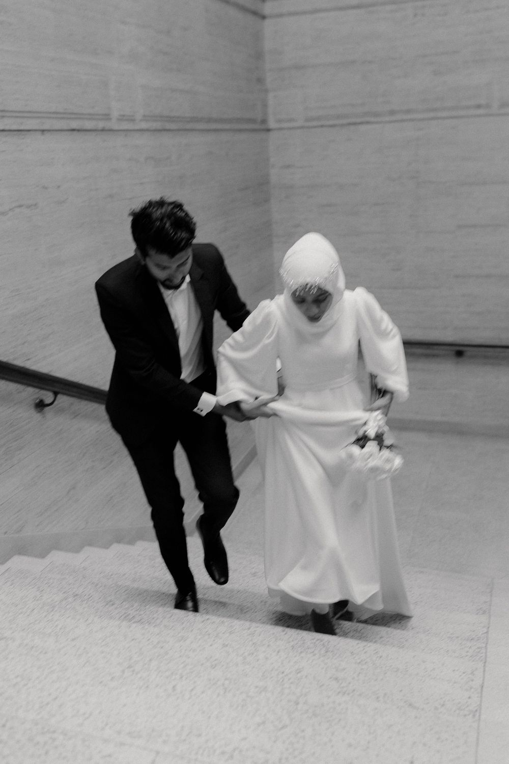 A sequence of black and white photos showing two figures in contrasting black suit and white dress moving across a floor.