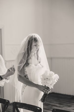 A black and white photo series shows a bride in a flowing veil holding a bouquet in different elegant poses.