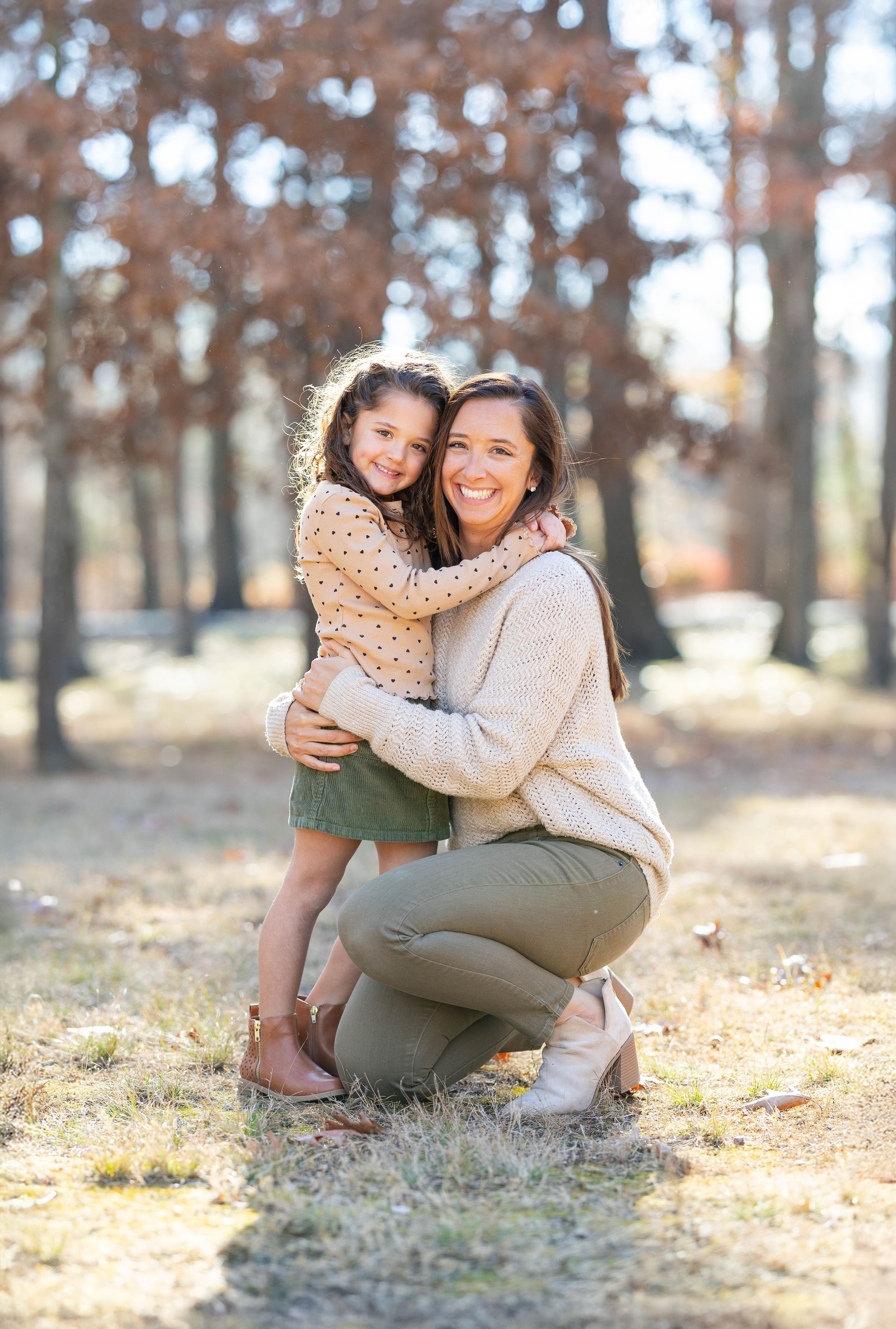 A tender moment shared between parent and child during an autumn photoshoot in the woods.