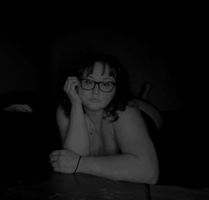 Moody black and white boudoir portrait in low light.