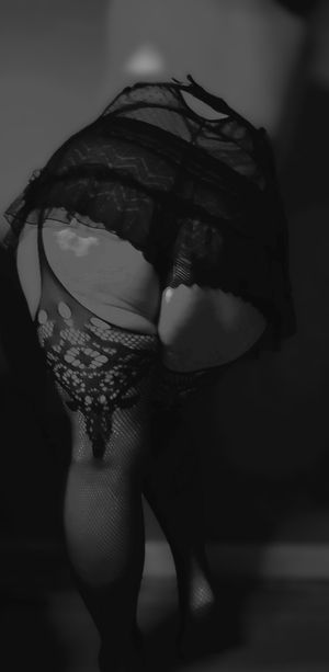 Artistic close-up of lace and fishnet textures in monochrome lighting.