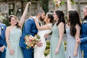 Wedding party in seafoam green dresses reacts joyfully during outdoor ceremony celebration moment.