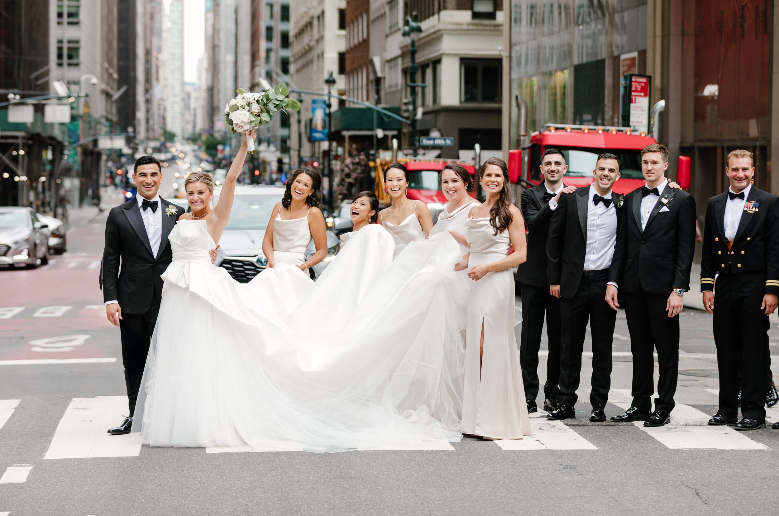A wedding party poses in formal attire while crossing an urban street in Chicago.