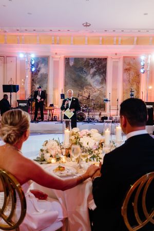 Live band performs at an elegant wedding reception with ornate decor, floral centerpieces and soft lighting.