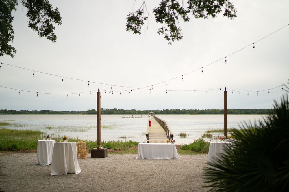 A white tablecloth reception setup in front of a private pier at a Charleston wedding