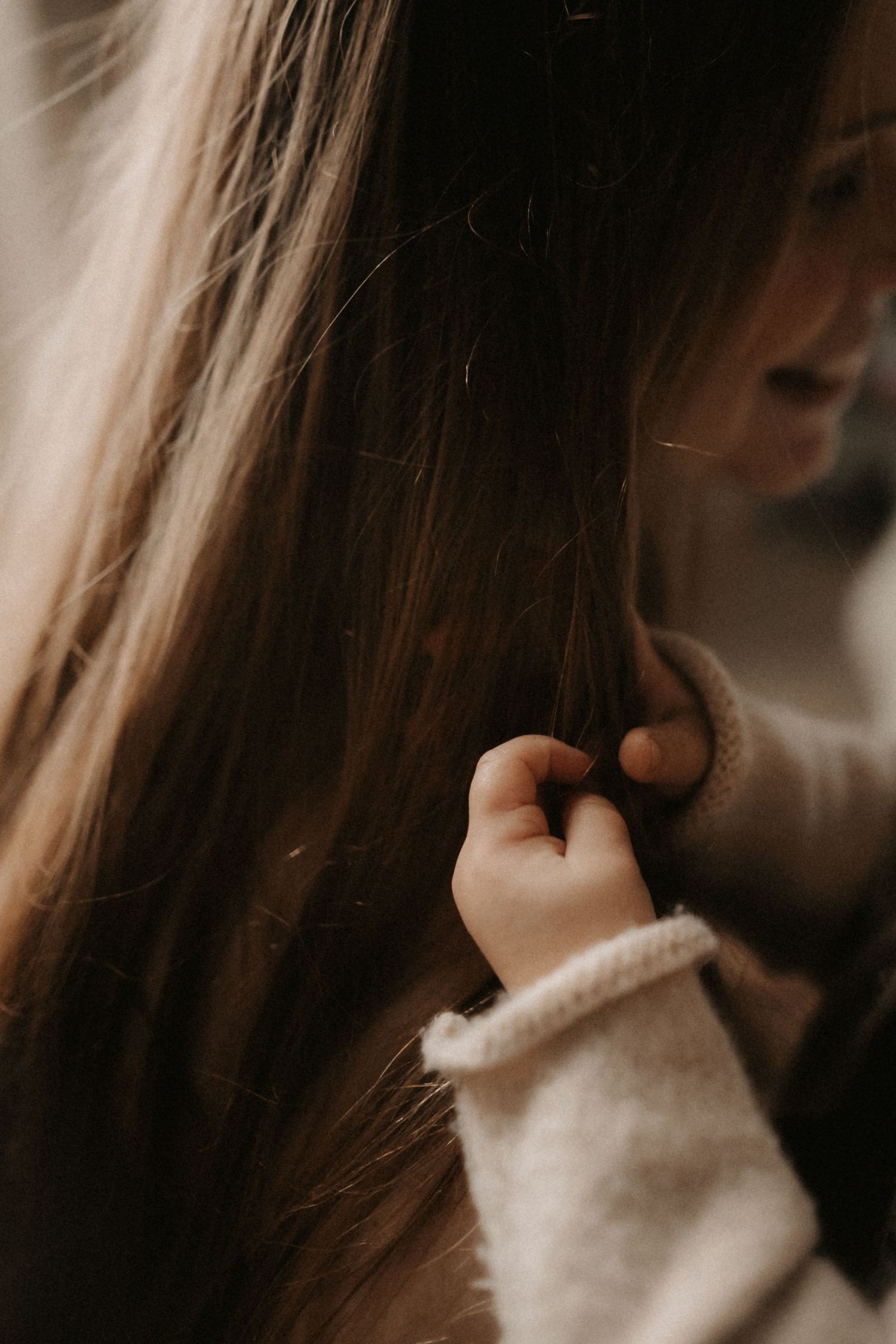 Close up portrait in muted tones showing long hair and white turtleneck sweater.