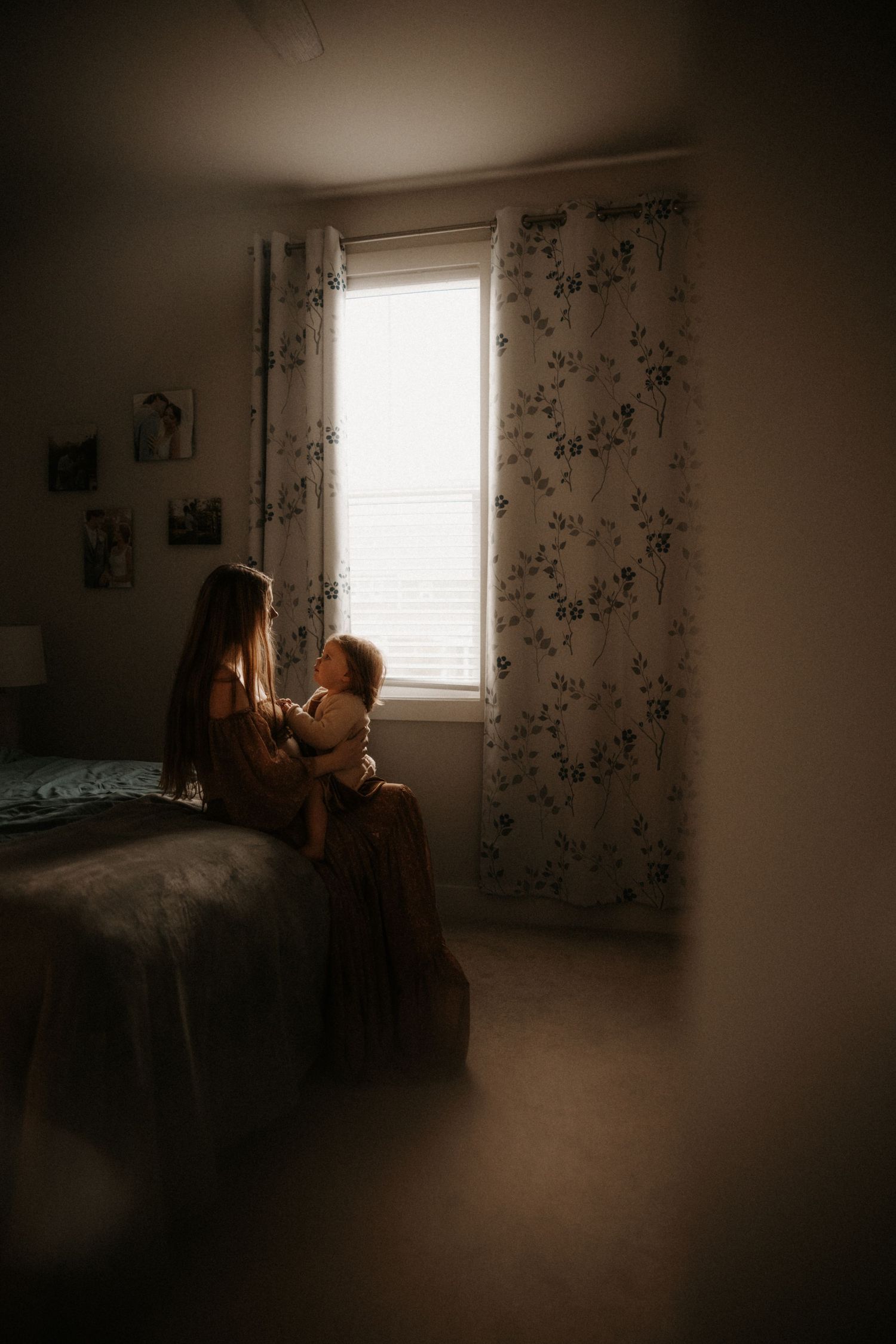 Moody series of bedroom photos showing silhouettes and shadows against floral wallpaper and window light in dark ambiance.