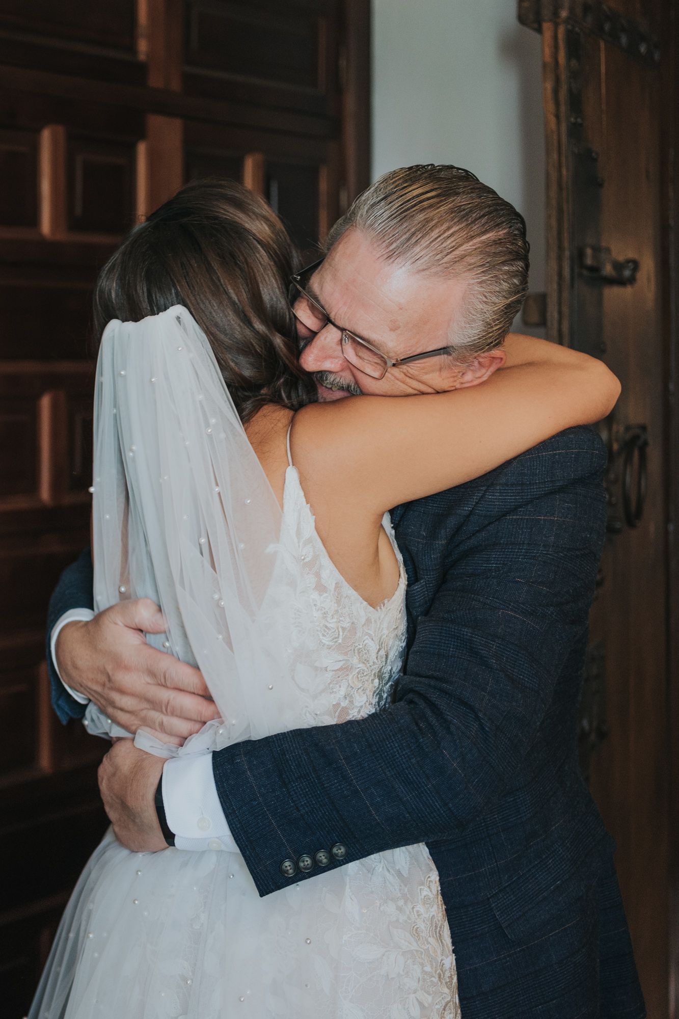An emotional embrace during a wedding ceremony in formal attire.