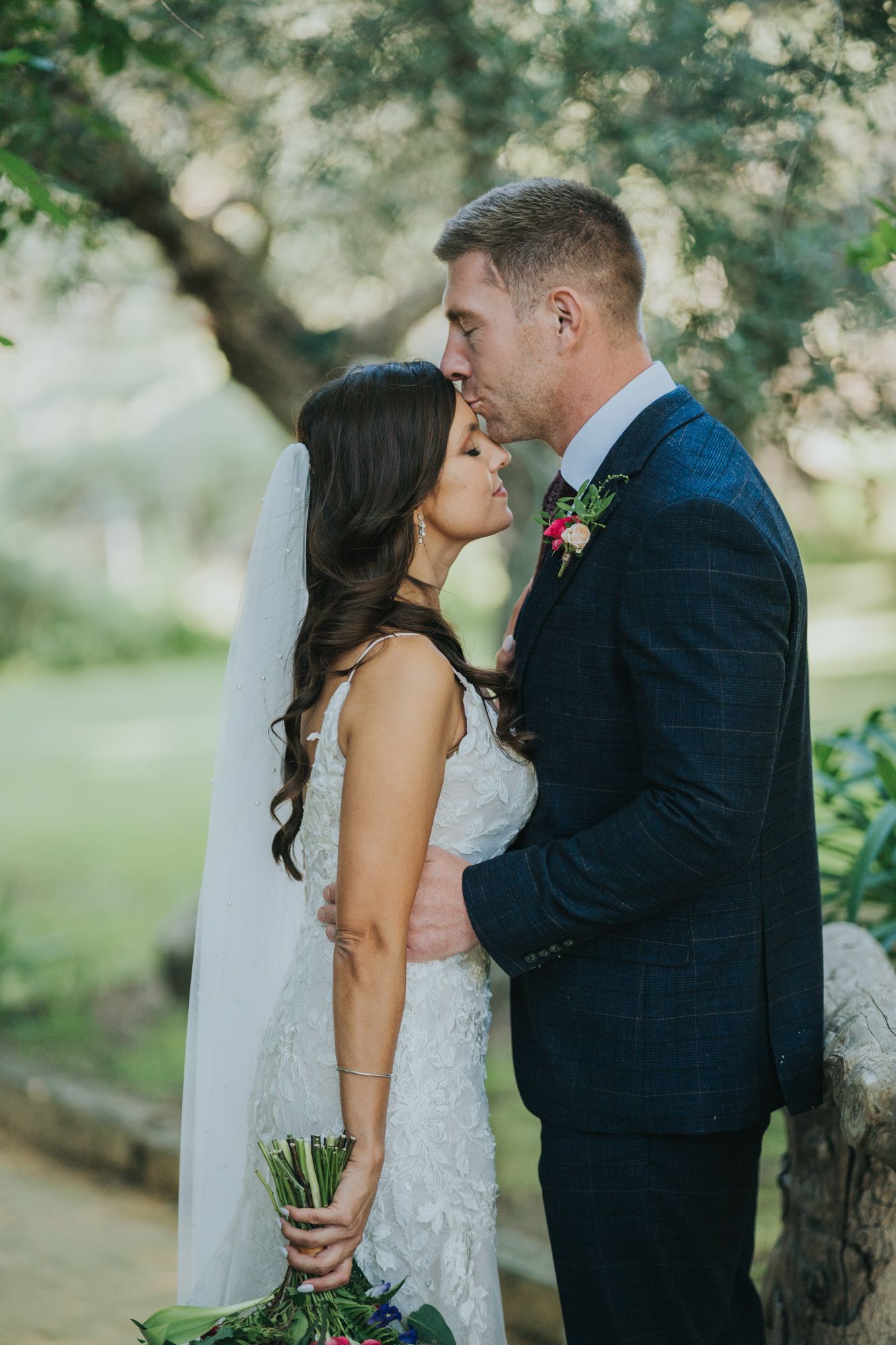 A romantic moment captured between newlyweds in a garden setting with soft natural lighting.
