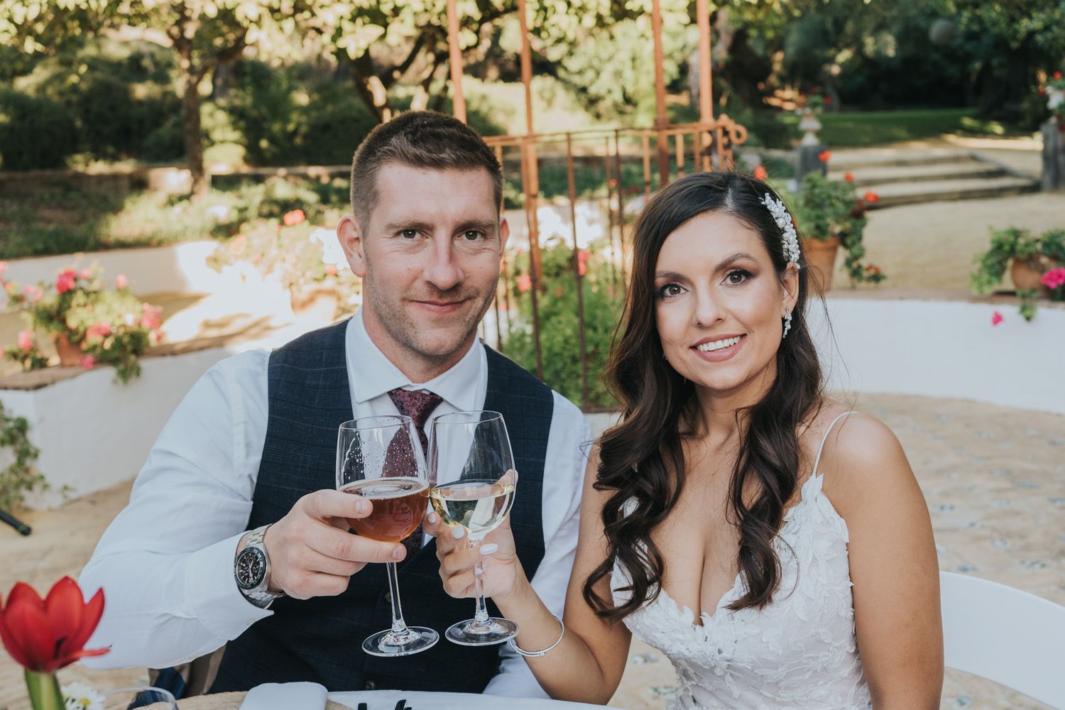 A couple toasts with wine glasses at an outdoor wedding reception.