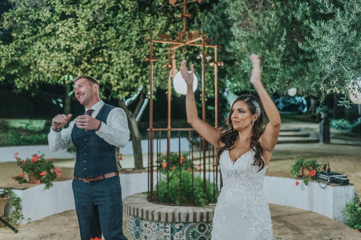 Happy newlyweds celebrating during their outdoor garden wedding reception with festive energy and dancing.