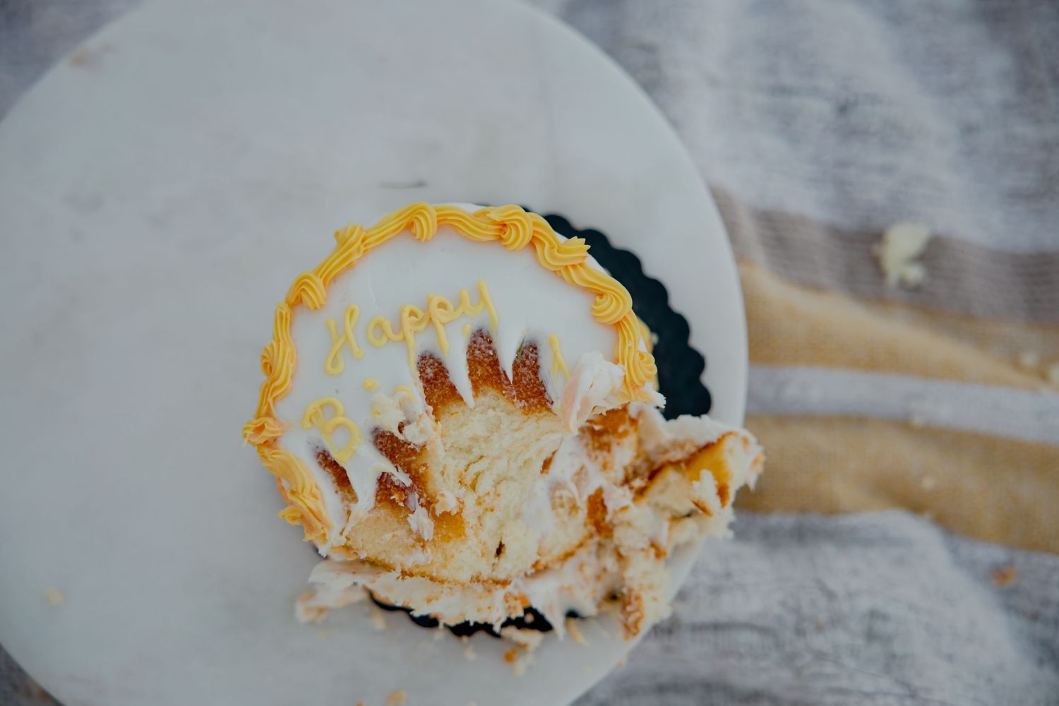 Smashed yellow cake on white plate showing signs of a joyful celebration.