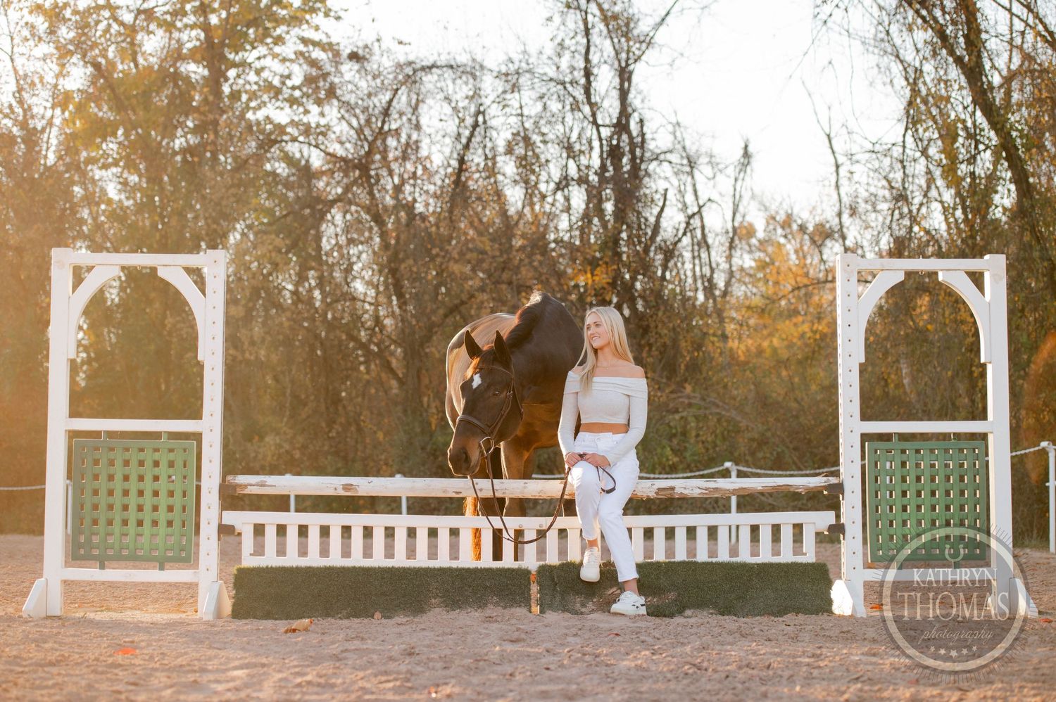 White fence posts frame a scene with a horse and someone in athletic wear during golden hour.