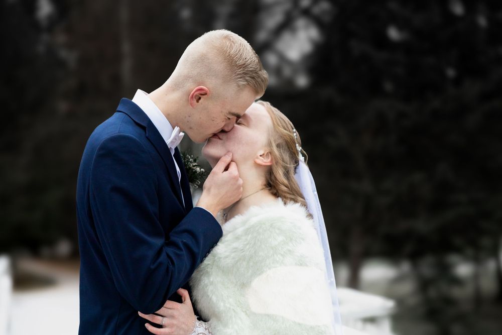 Hääpari suutelee Ainolanpuistossa valokuvaaja Milja Paanasen ikuistettavana.