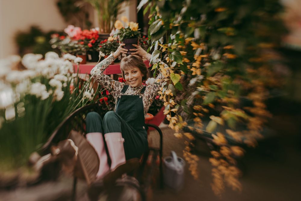 Dreamy spring portrait in a garden with warm bokeh lighting and vibrant flowers in the background.