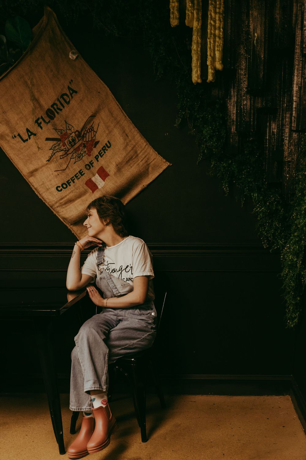 Moody coffee shop scene with vintage style decor and a burlap coffee sack hanging on dark wooden wall.