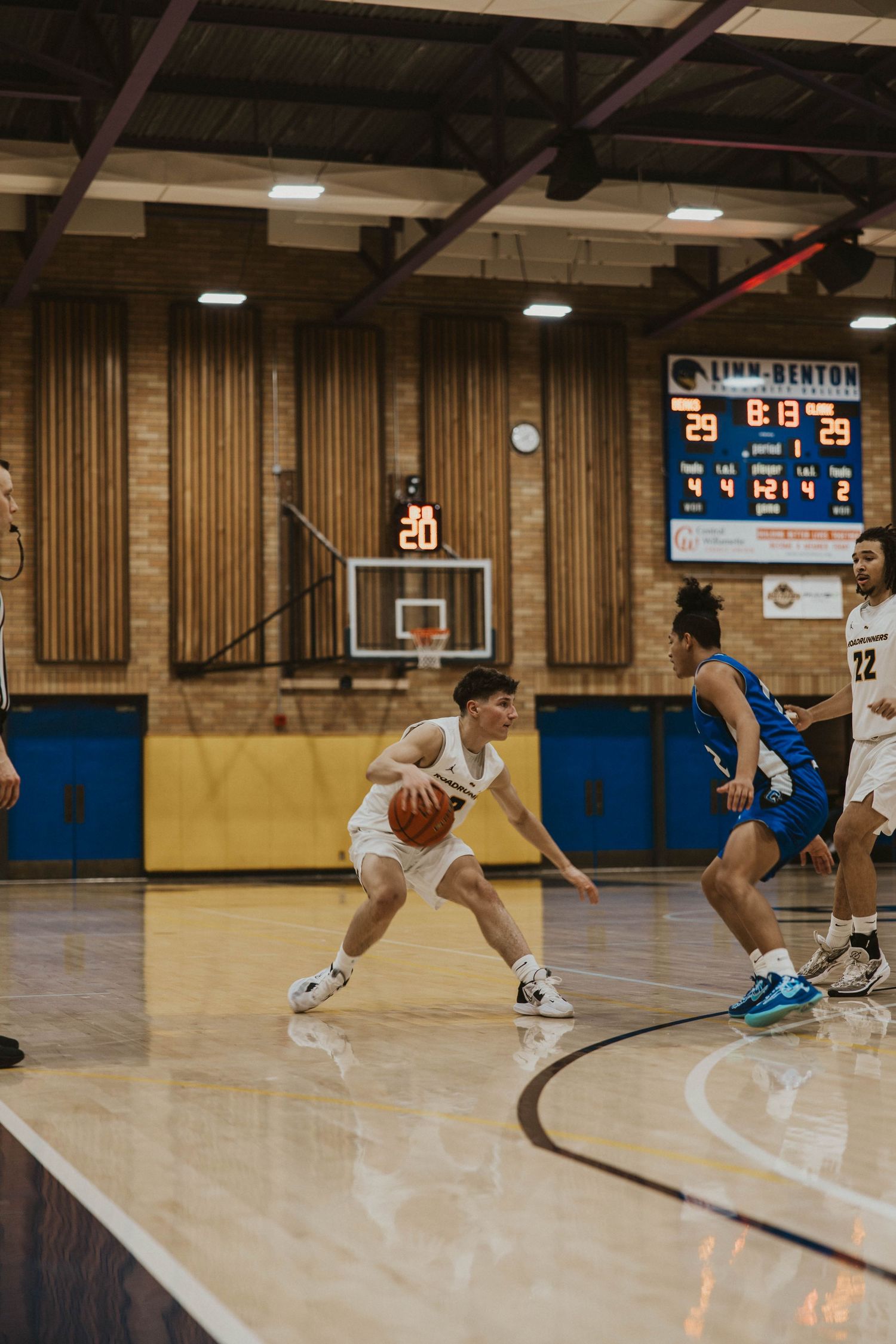 Players executing basketball moves and dribbling sequences during practice on wooden court.