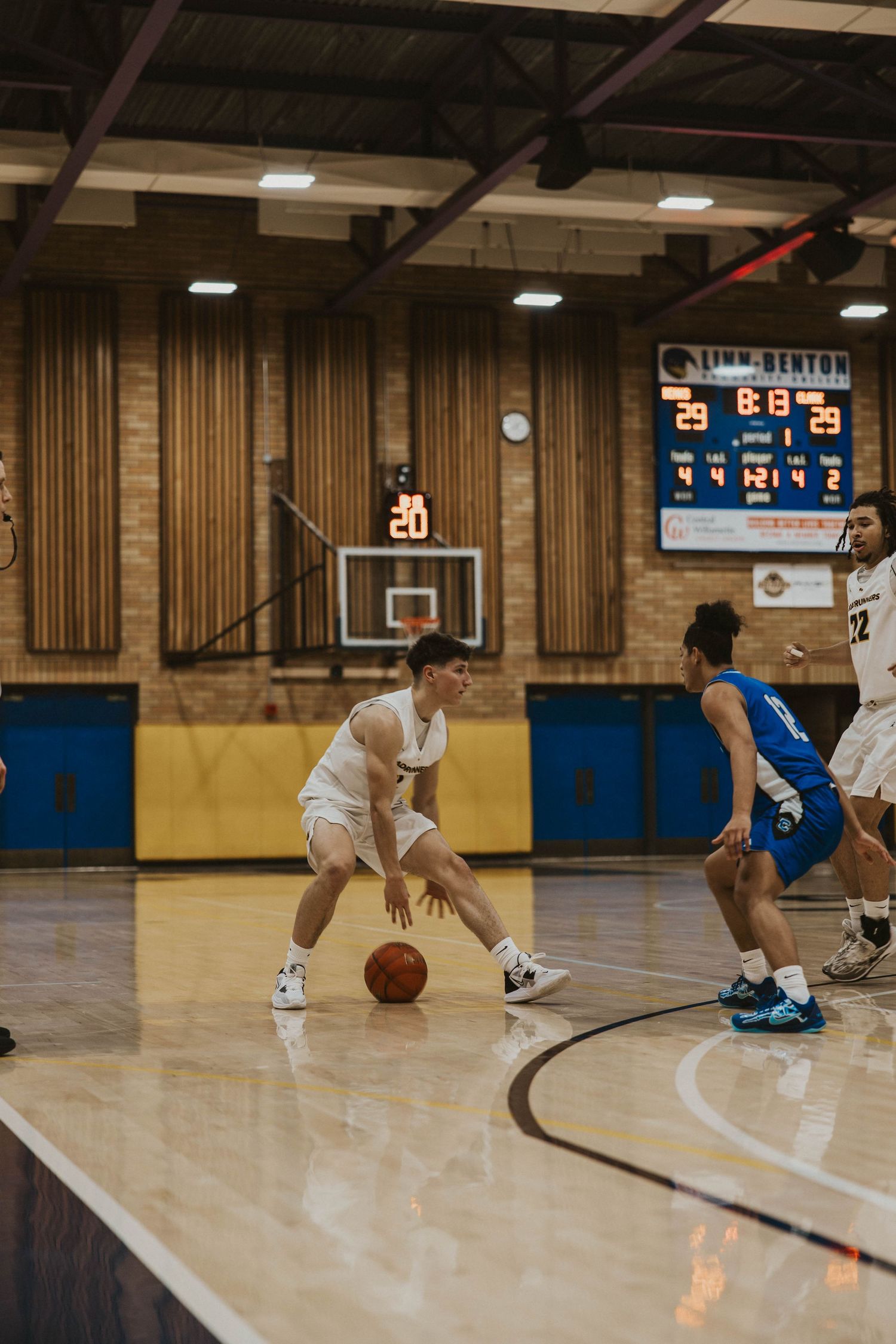 Players demonstrating low dribbling techniques during basketball practice session.