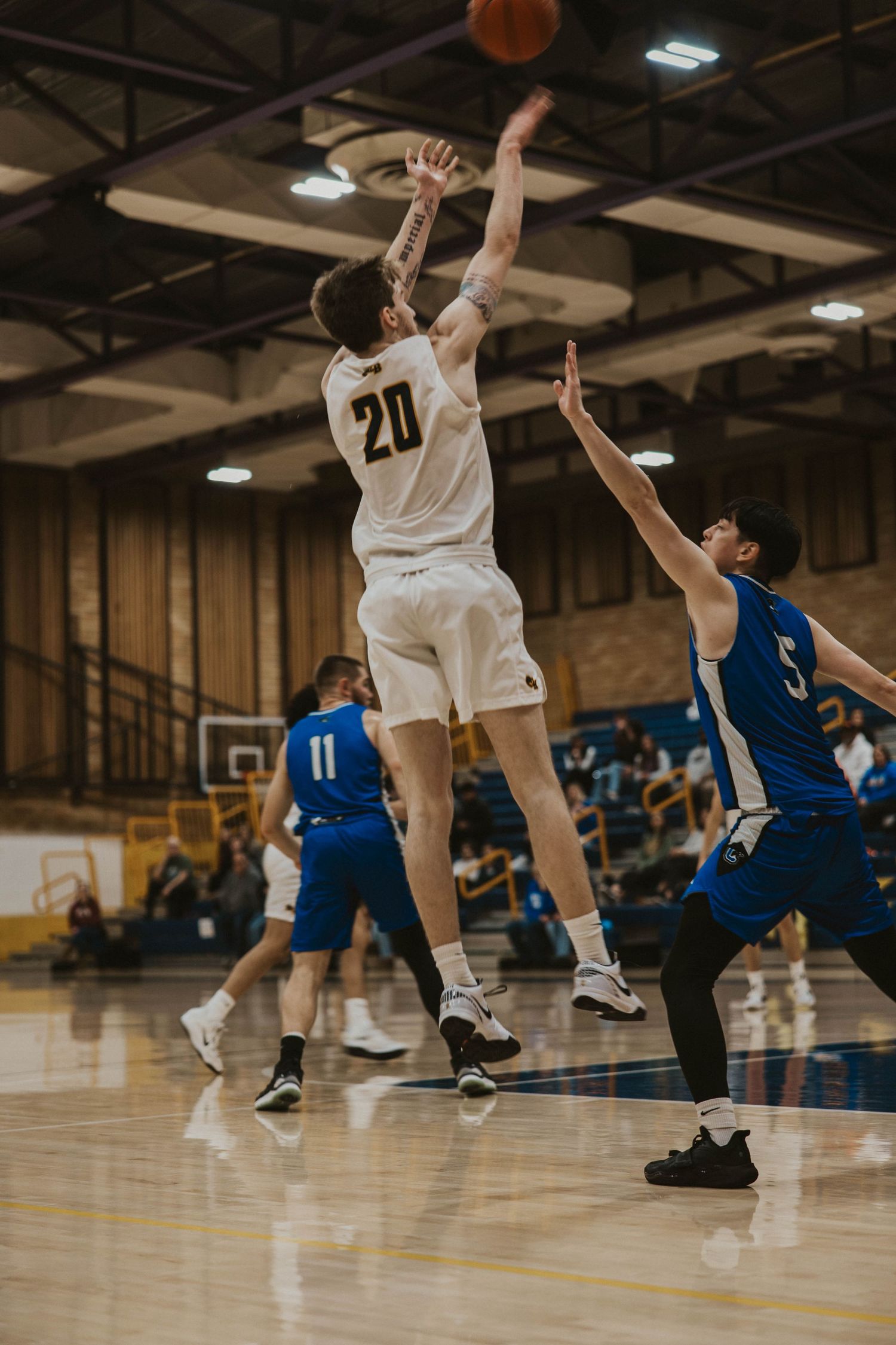 Basketball players jumping and competing for possession during an intense game moment.