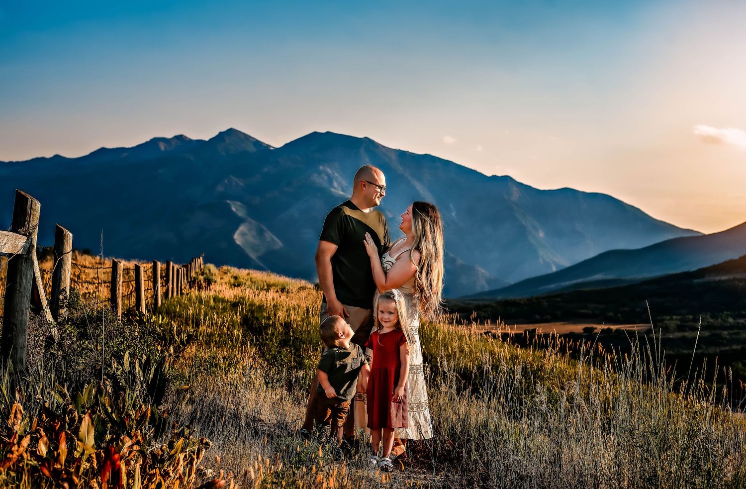 couple embracing while kids look at them on the mountains in Snowbasin
