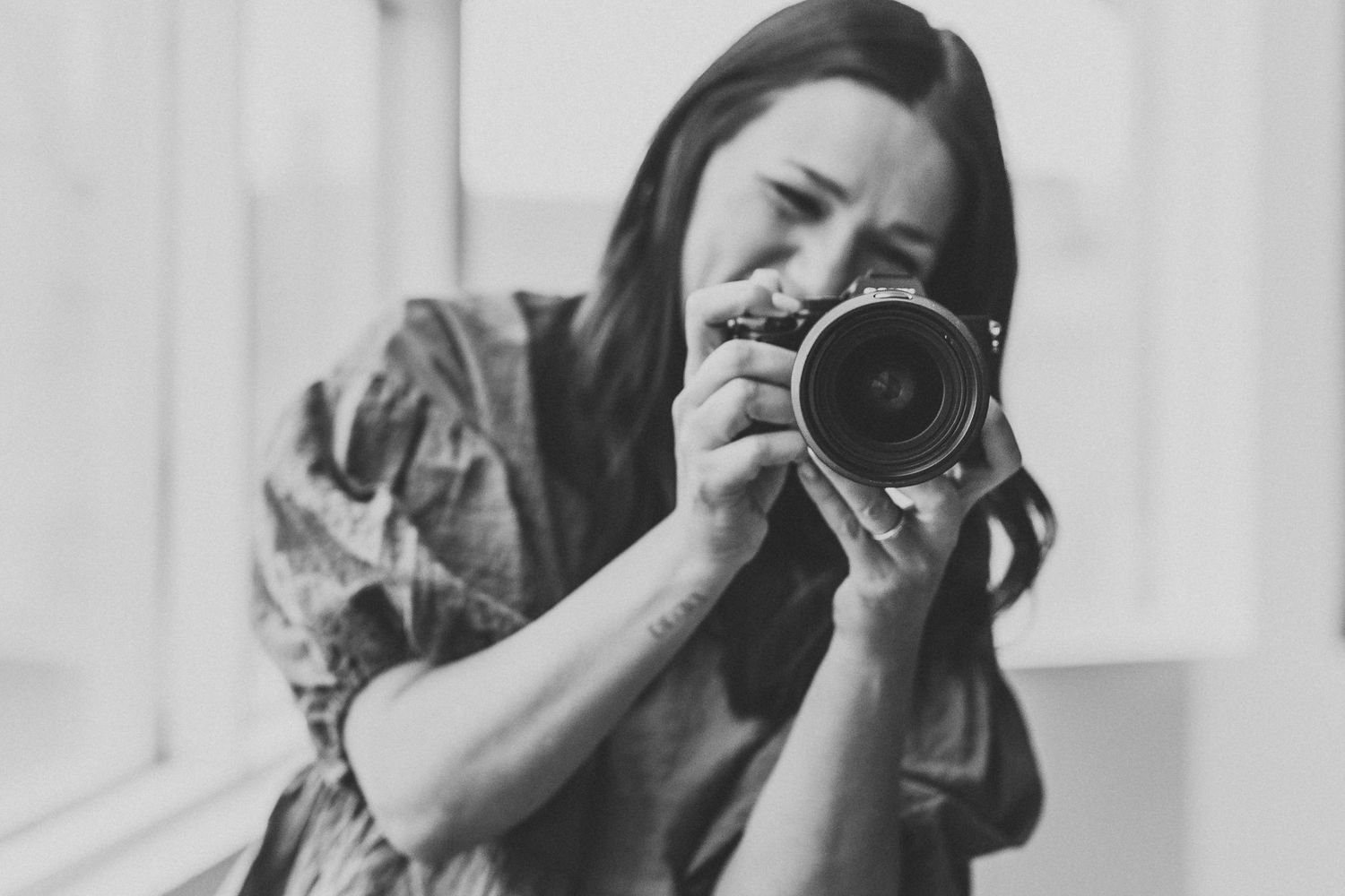 Overhead view of a notebook, camera, soda, and photographs in black and white