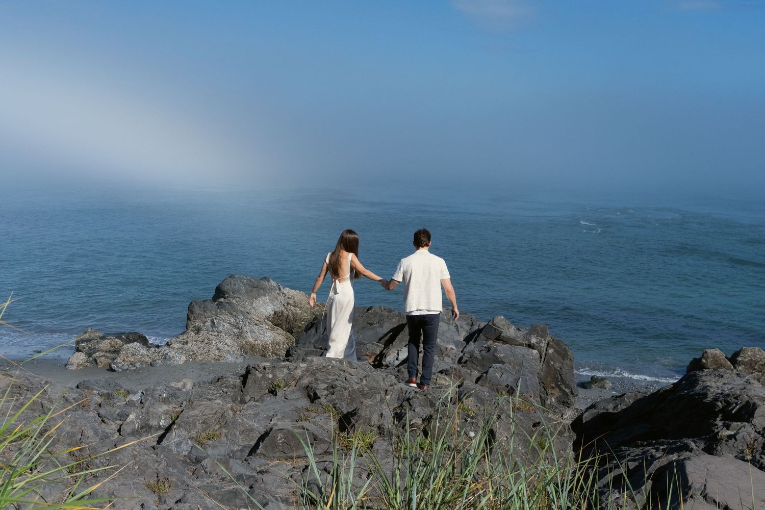 A couple posing on a cliff at Engagement Photoshoot at Deception Pass State Park in WA, Captured by Savvy Photography.