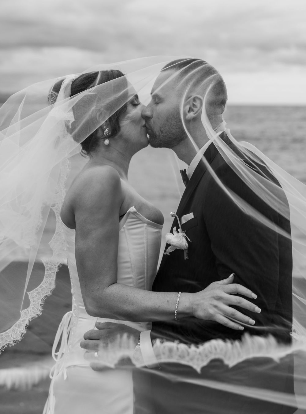 A romantic black and white photo sequence showing a couple in wedding attire sharing a tender kiss.
