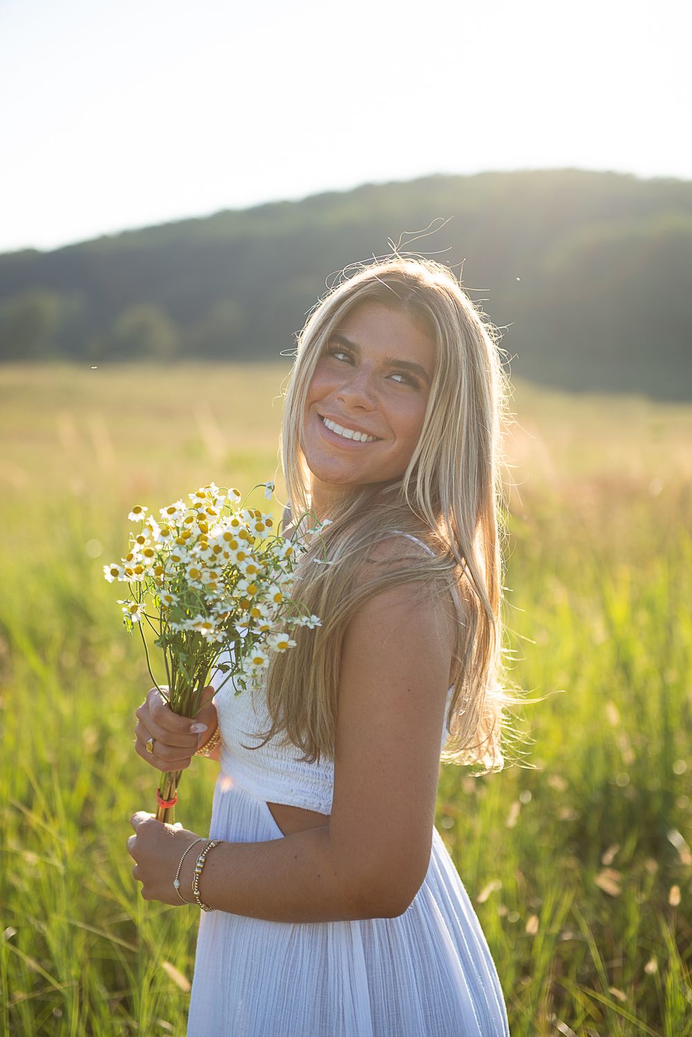 A series of candid shots in a sunlit meadow with wildflowers and a white summer dress creating a dreamy atmosphere.