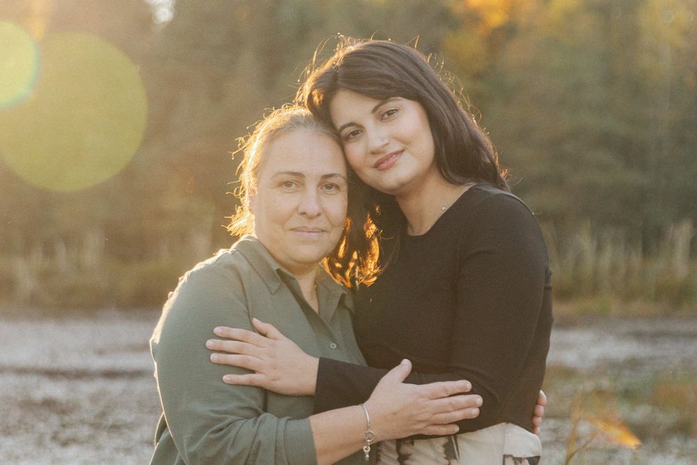 Loving couple embracing during golden hour with lens flare and autumn scenery.