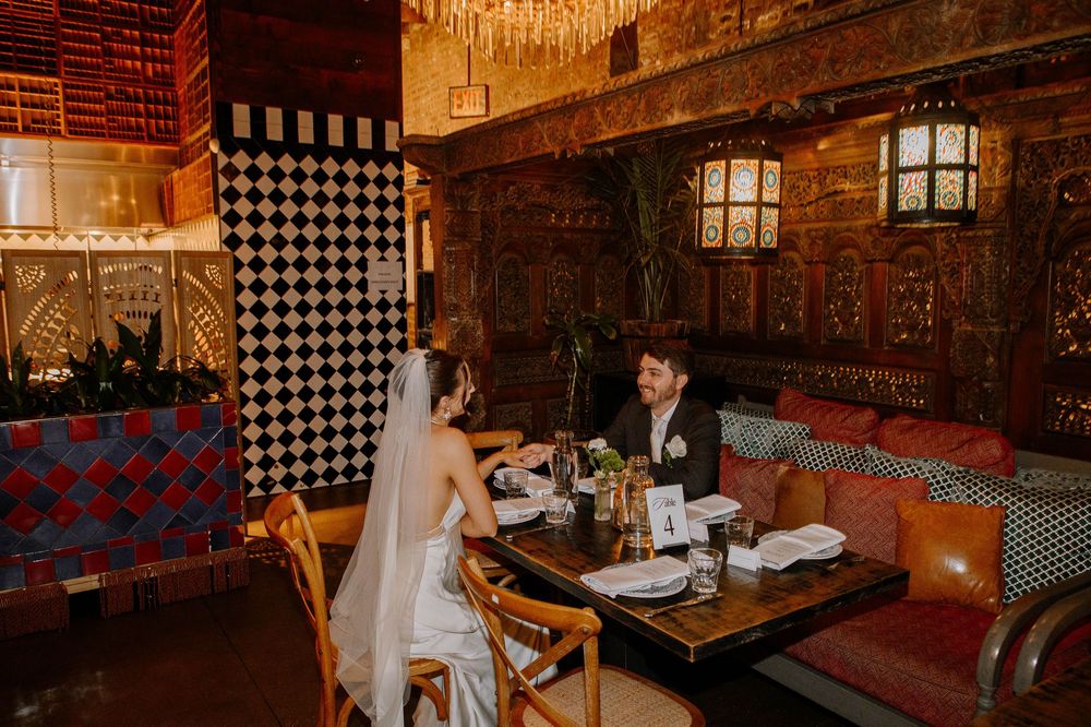 Rustic restaurant interior with wooden beams, checkered patterns, and warm ambient lighting creates cozy dining atmosphere.
