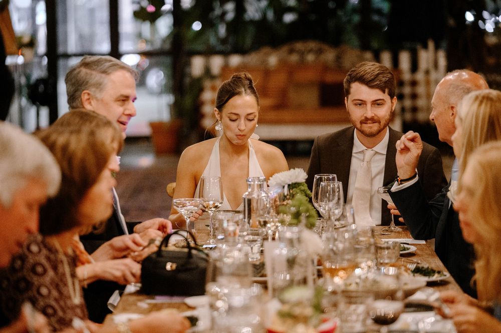 Guests gathered around elegant dining tables enjoying conversation during an evening celebration.