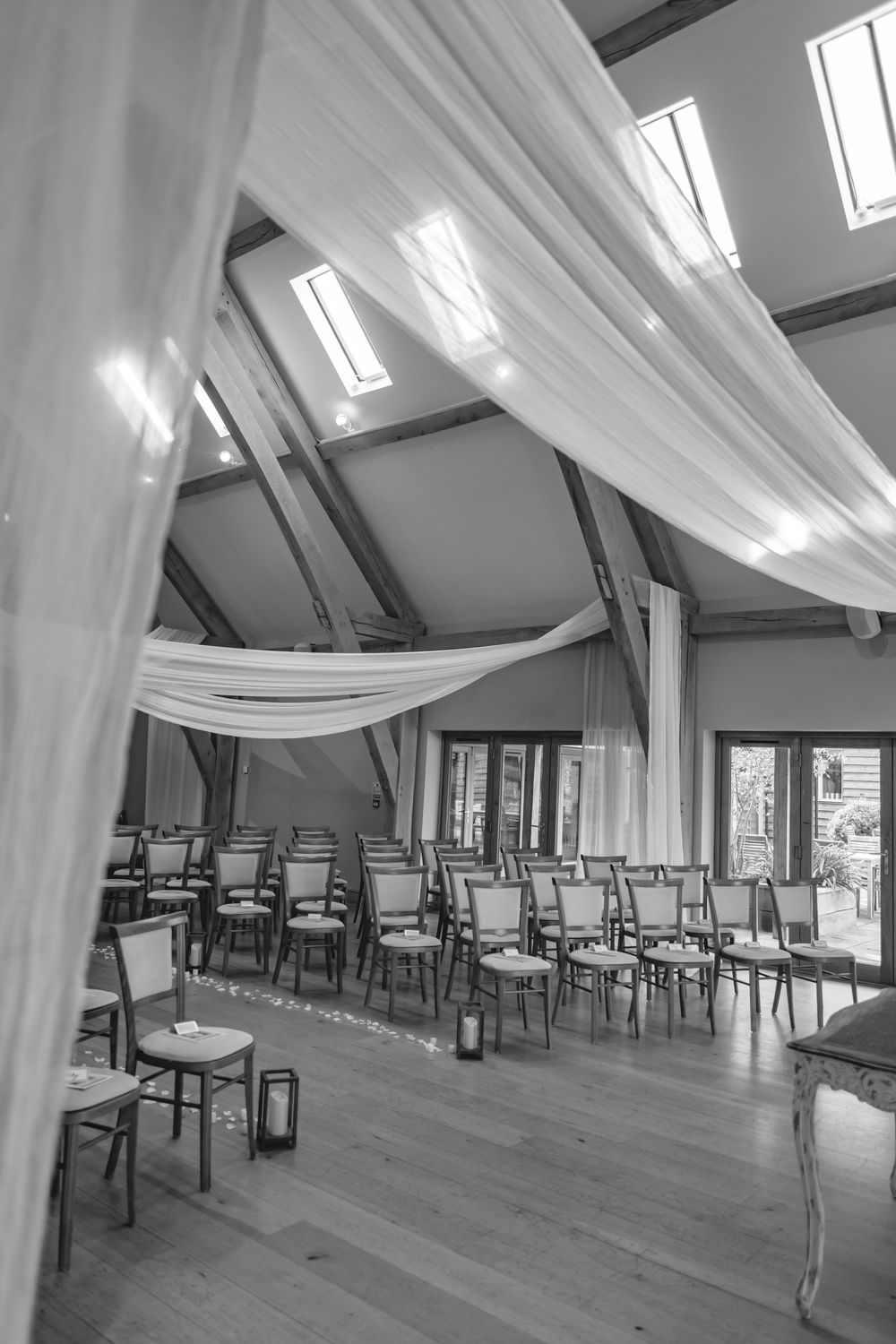Modern wedding venue with white draping and natural light from skylights.