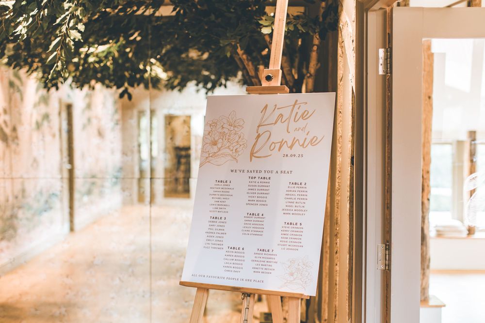 Wedding seating chart displayed on window panes in elegant calligraphy.