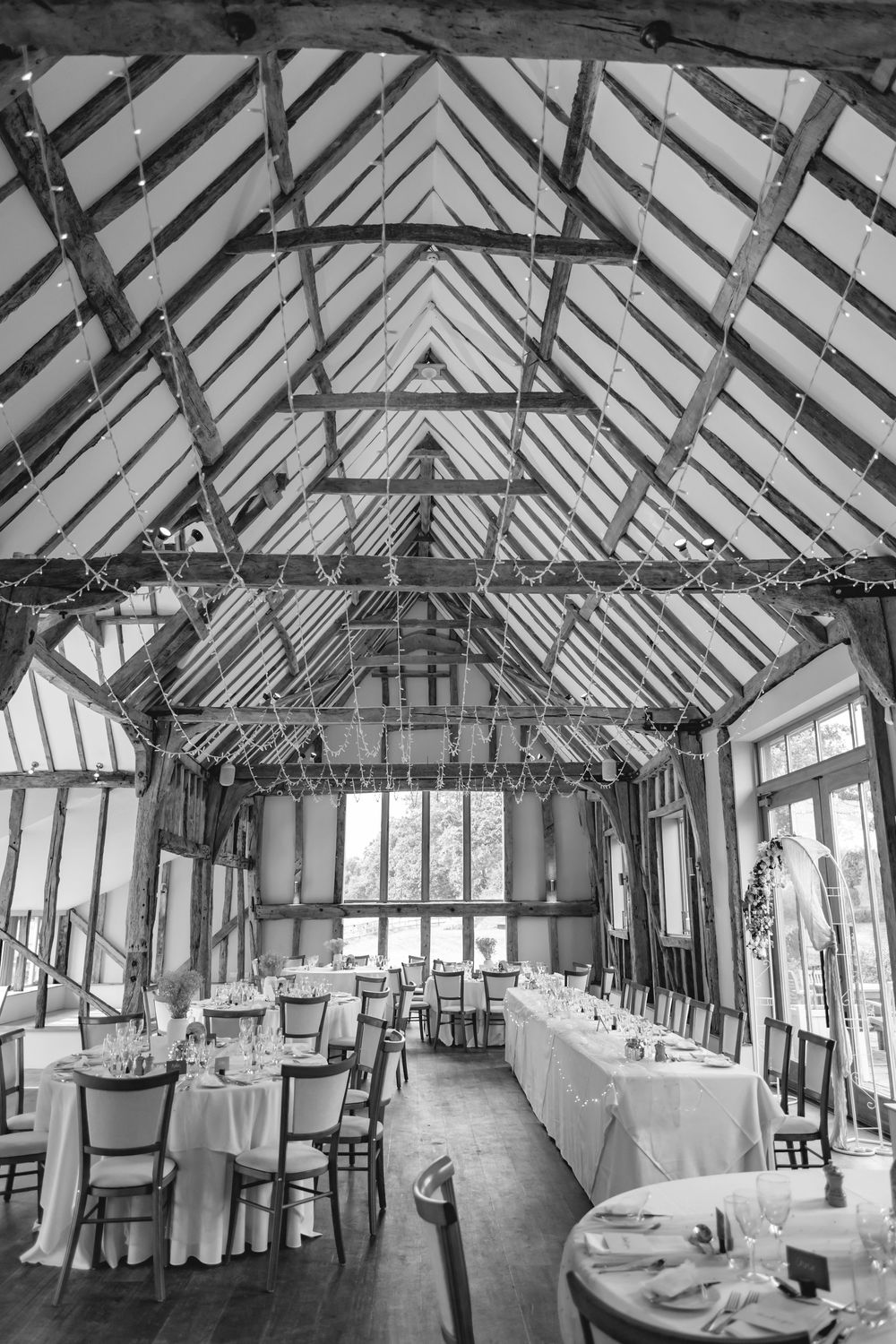 Rustic barn wedding venue with exposed wooden beams and elegant table settings.