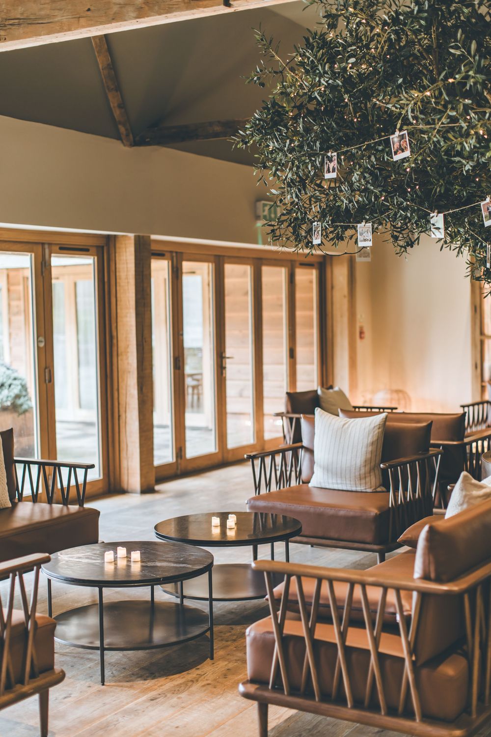 Modern rustic indoor venue with wooden furniture and hanging greenery creating an elegant atmosphere.