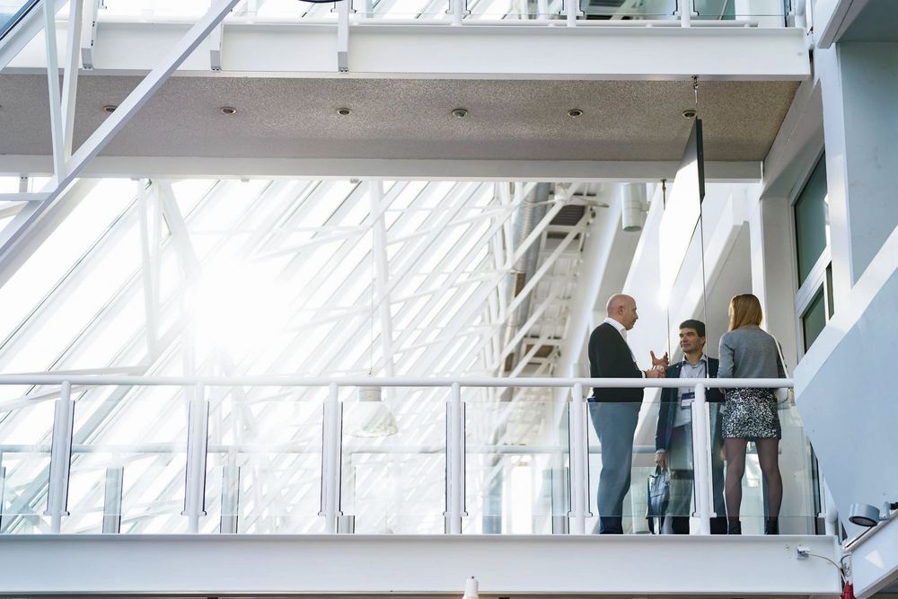 Business professionals having a meeting on a bright modern office building balcony.