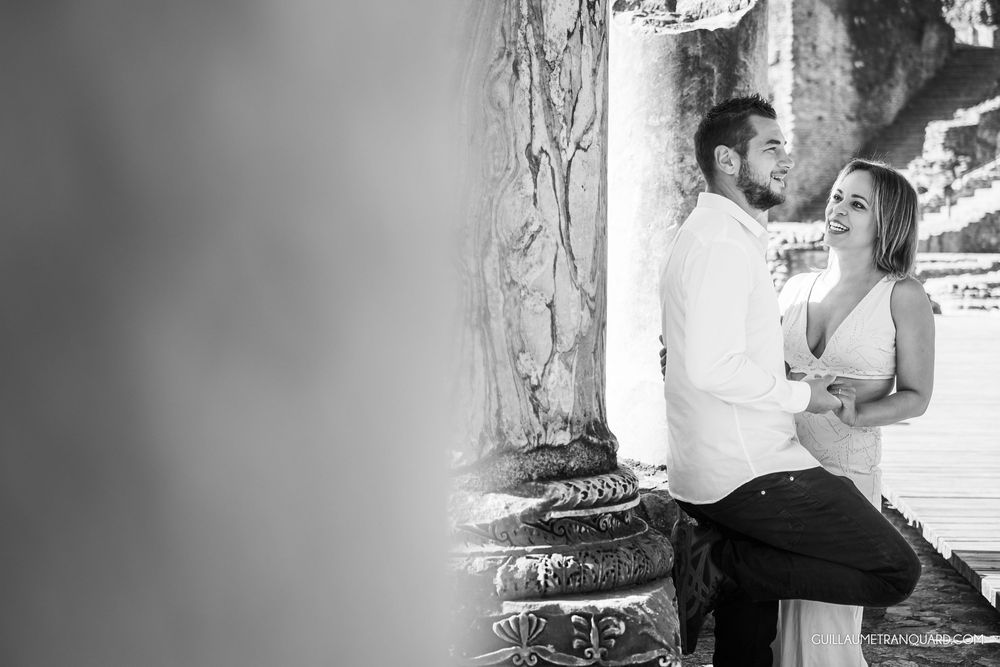 Black and white engagement photos captured against rustic stone walls.
