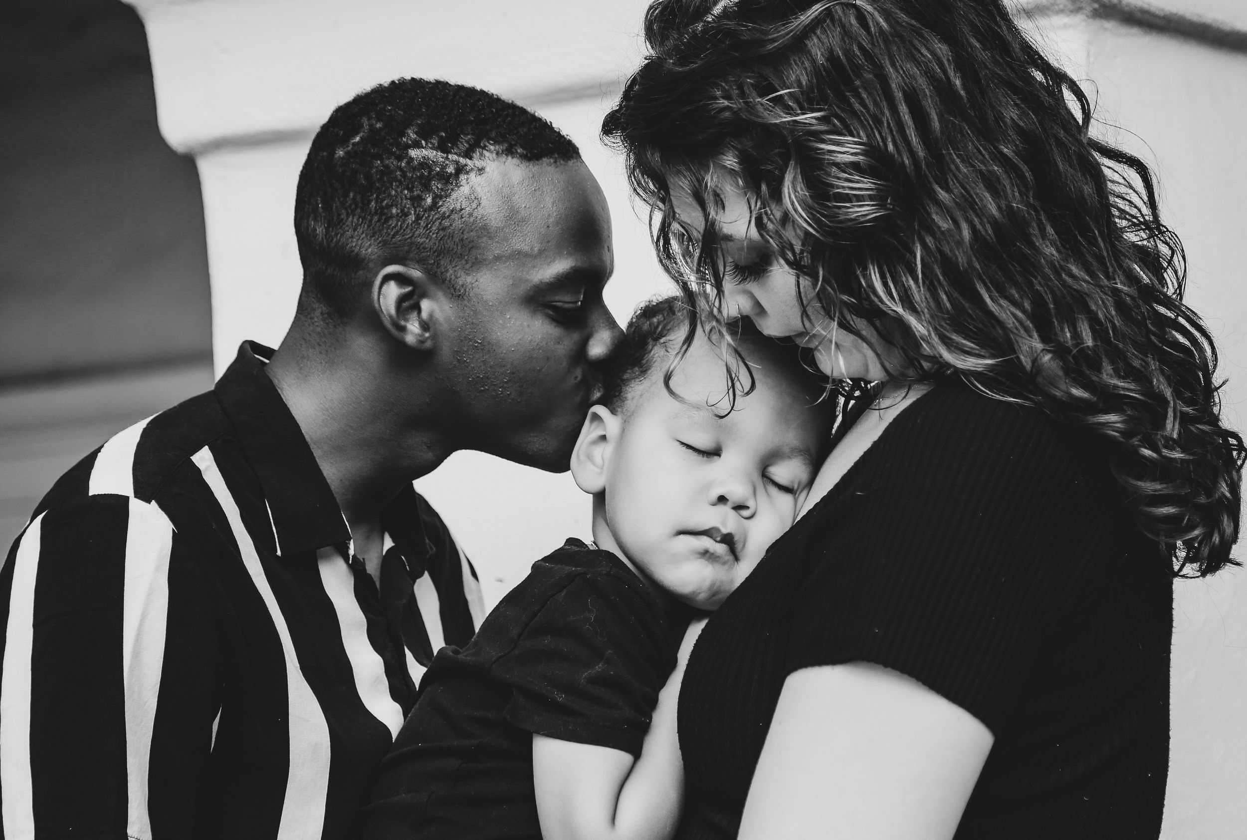 Series of intimate black and white portrait photographs in dramatic lighting.
