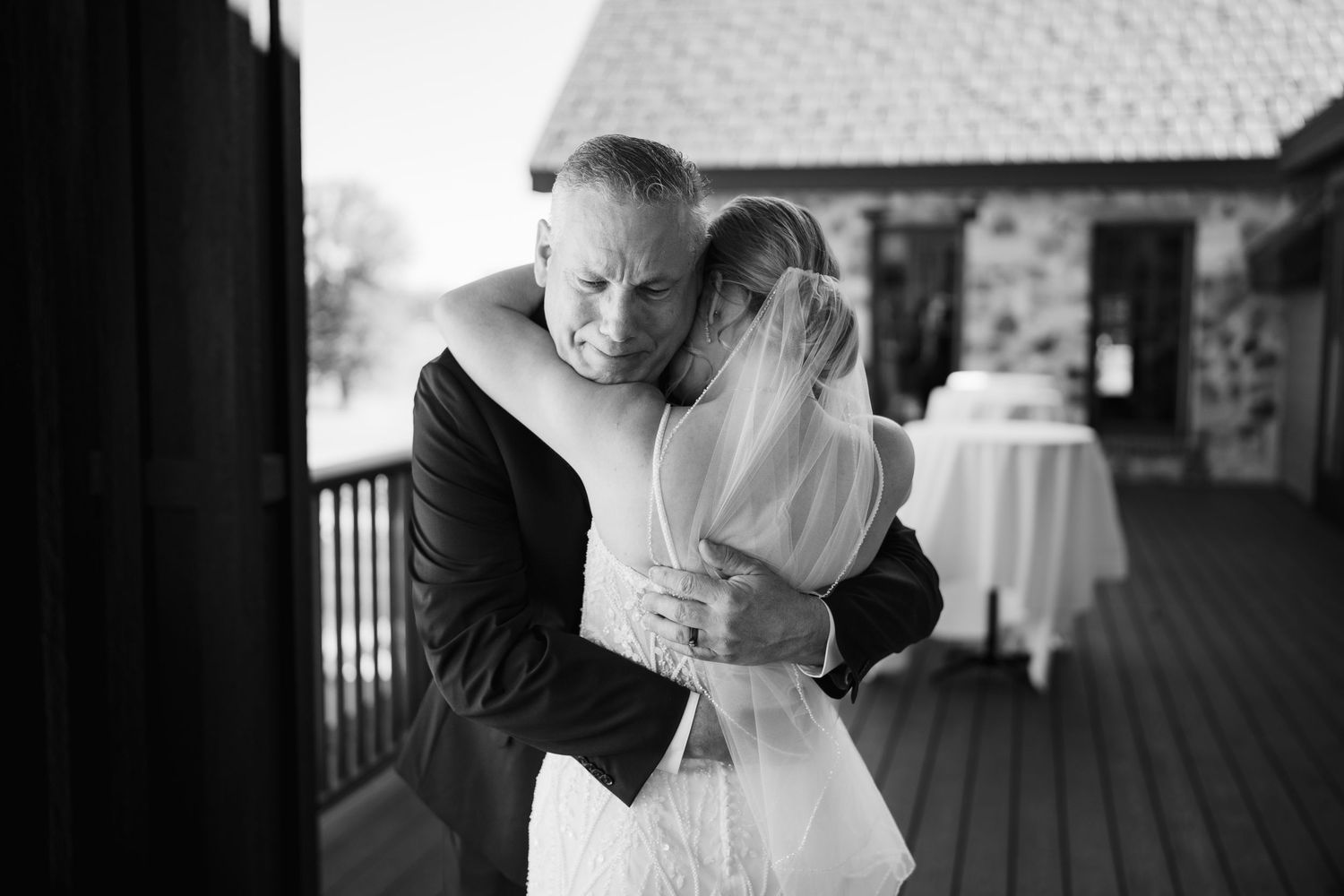 Black and white wedding photos showing romantic moments between newlyweds on a covered porch.