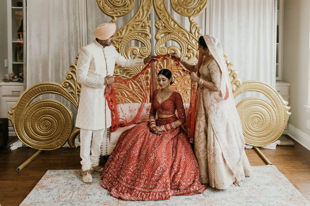 Elegant Indian wedding ceremony setup with ornate gold decor and traditional white and red color scheme.