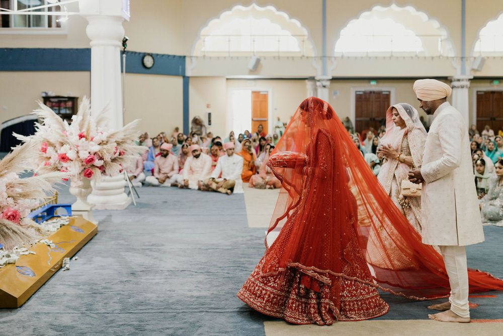 Traditional Sikh wedding ceremony taking place in decorated indoor venue.