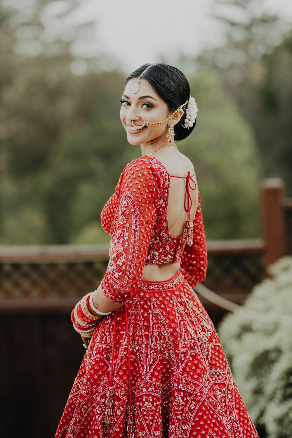 Detailed back view of an intricately embroidered red bridal lehenga with traditional Indian designs.