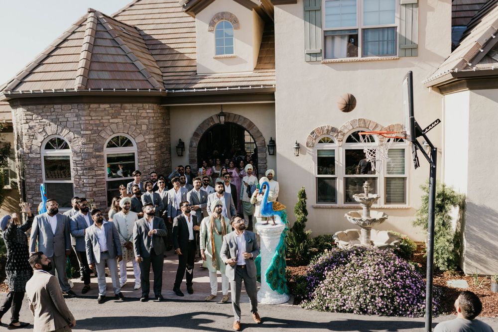 Wedding guests gathering outside a large residential home for celebration.