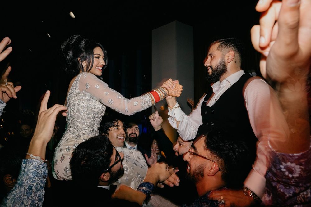 Wedding guests dancing and celebrating with joyful energy at a reception party.