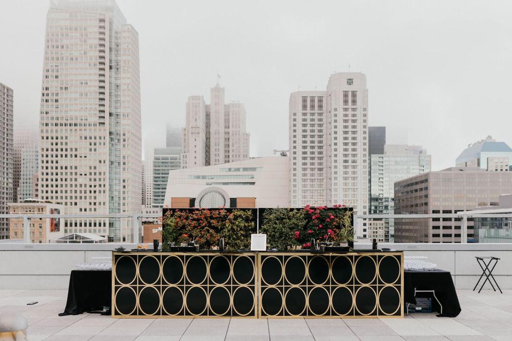 Contemporary black and gold wedding bar setup against an urban backdrop.