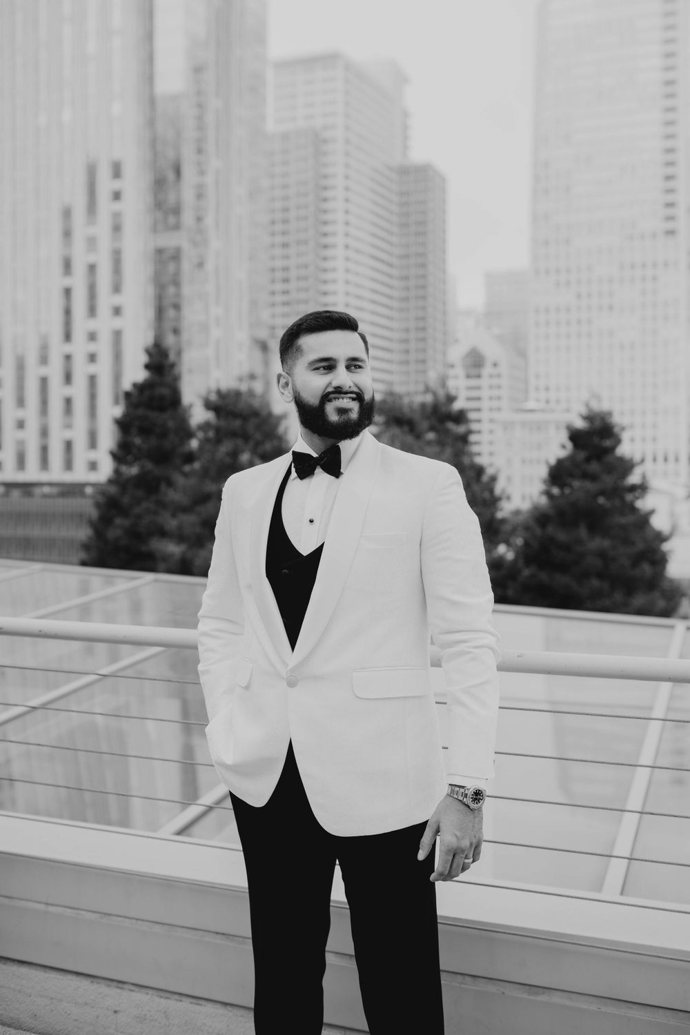 Formal black and white tuxedo with skyline backdrop.