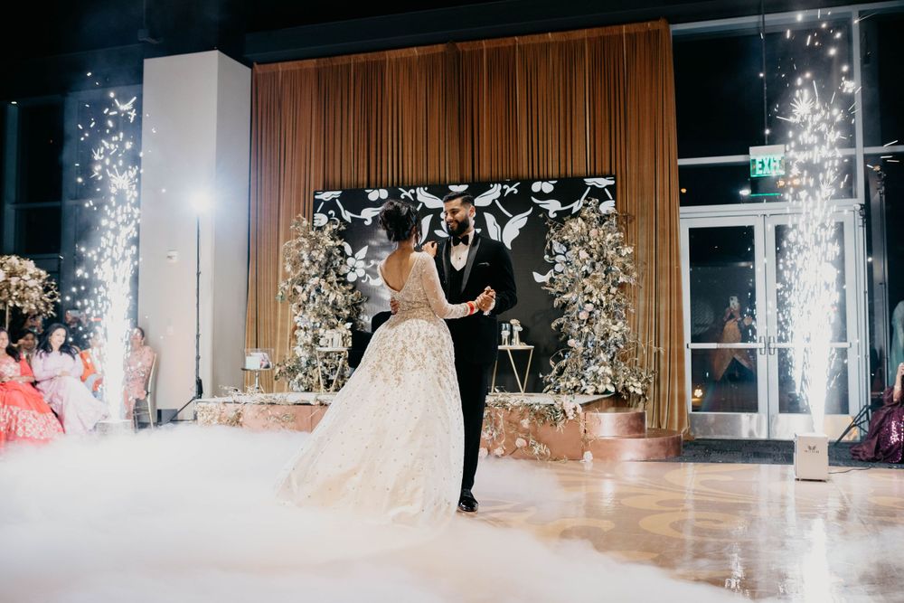 Magical reception moment with sparklers creating light trails against dark background.