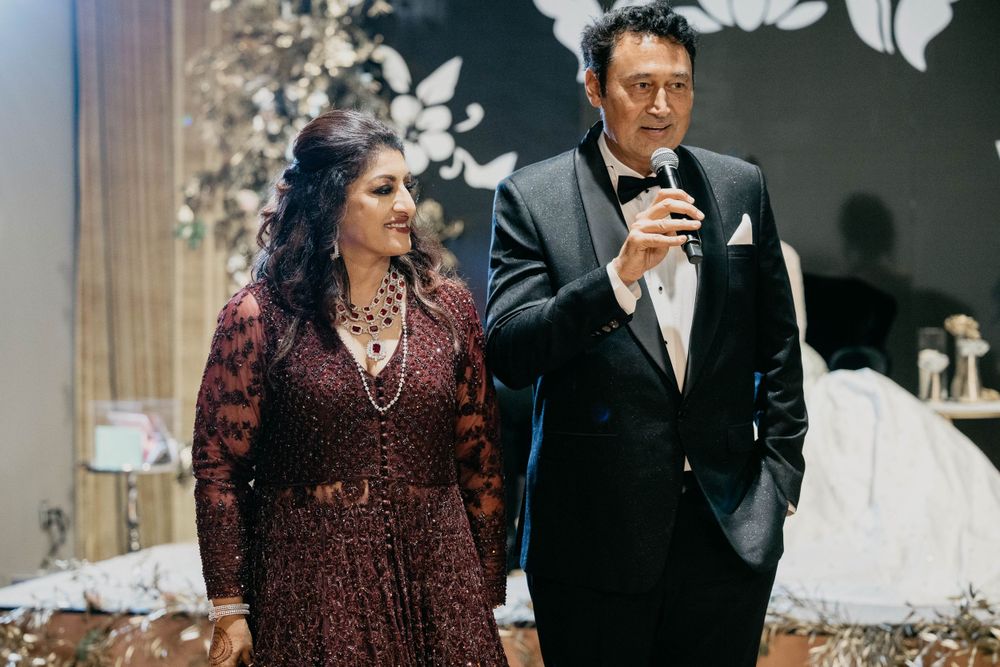 Guests in formal wear sit at decorated tables during an evening celebration.
