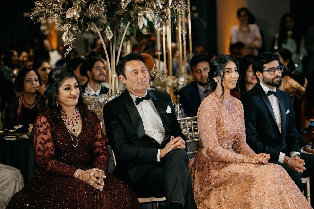 Wedding reception guests enjoy a formal dinner under elegant lighting.