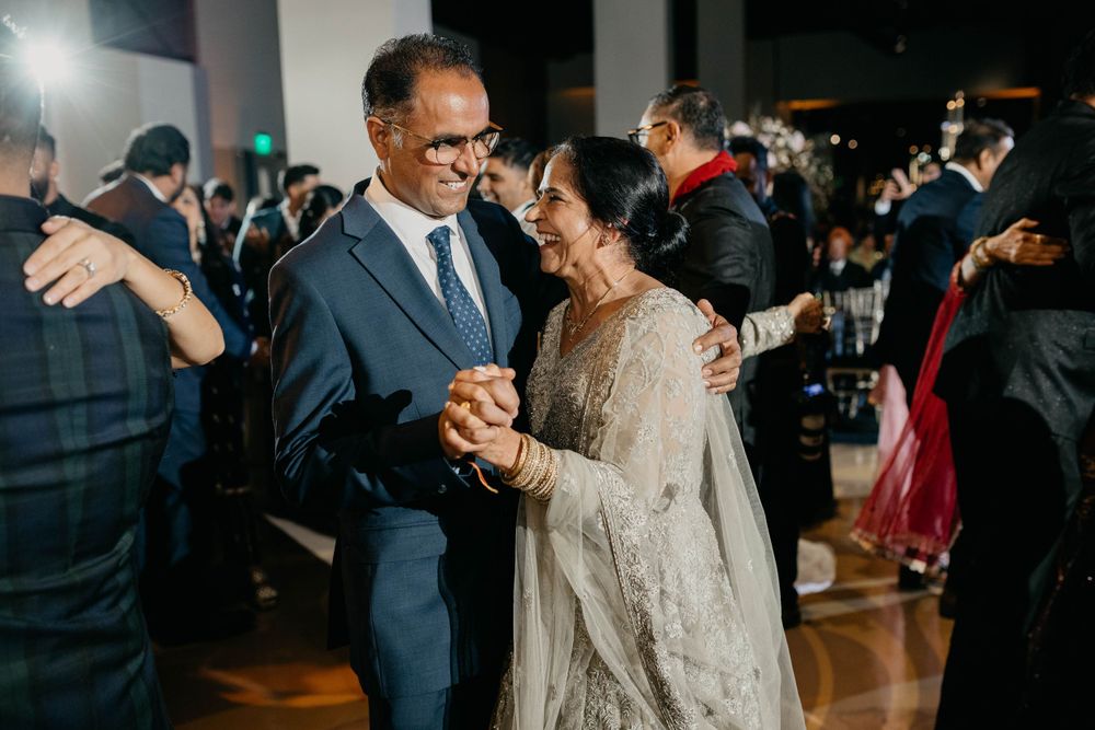 Wedding guests dancing and celebrating on a dark dance floor.